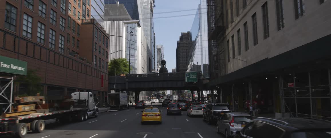 Driving on busy street in a downtown metro area with towers and buildings in the distance