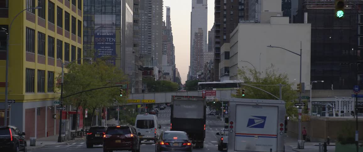 Vehicles driving on an avenue through new york city downtown at morning