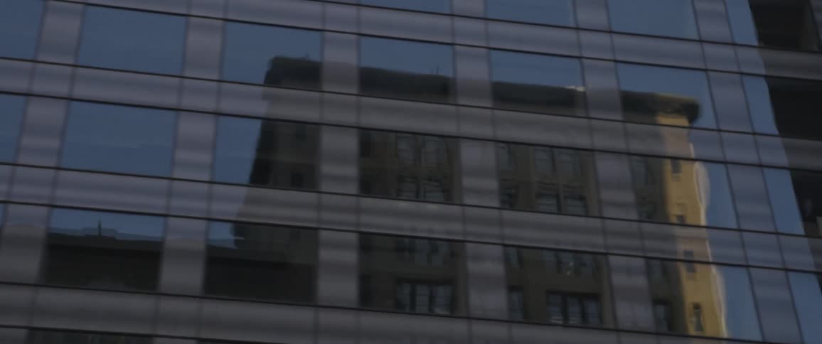Passing buildings close up with windows and reflections visible