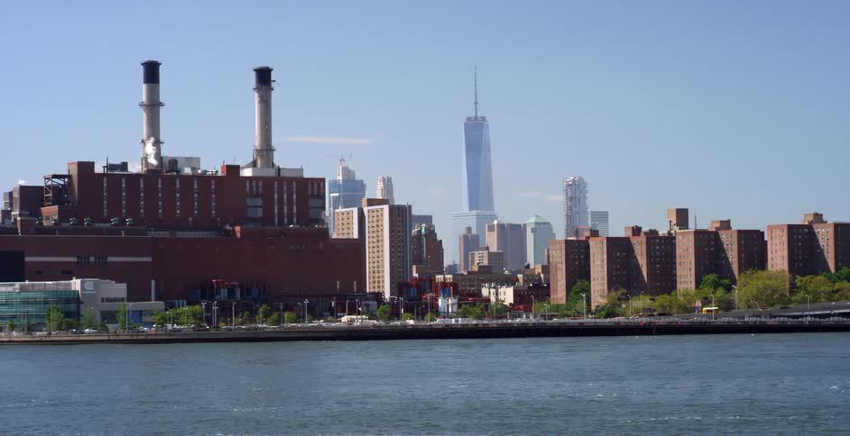 City skyline including a large industrial building beside a river