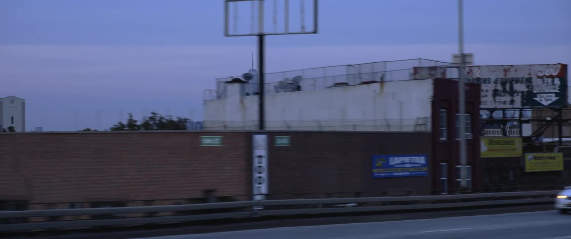 Cars driving down a street with the city skyline in the distance