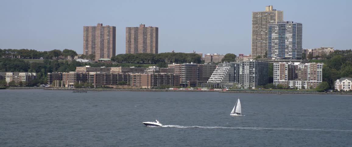 Motorboat and sail boat on a lake in a metro area
