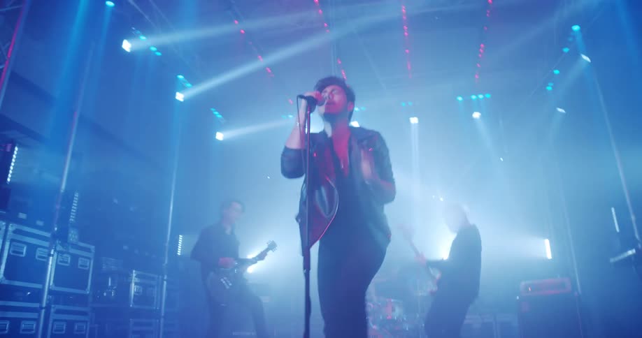 A band playing in a lit room with spotlights