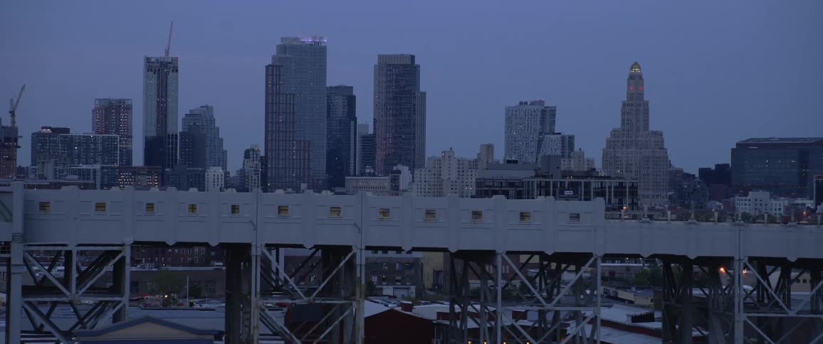 Distant big city skyline seen from a car driving across the bridge