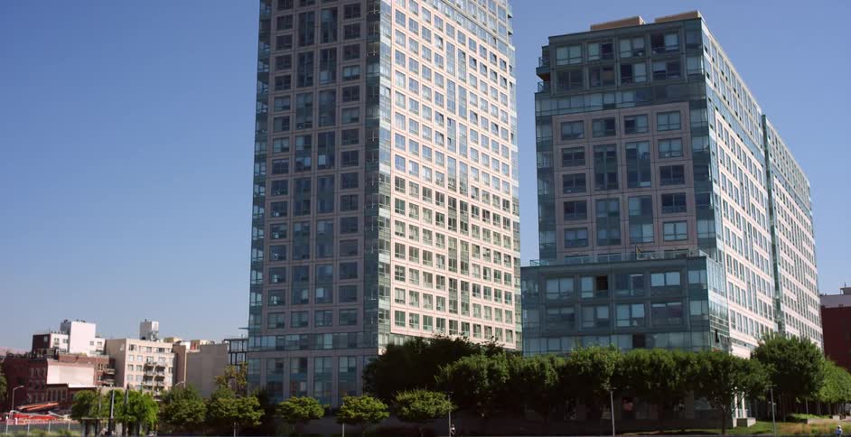 A row of large buildings are surrounded by trees