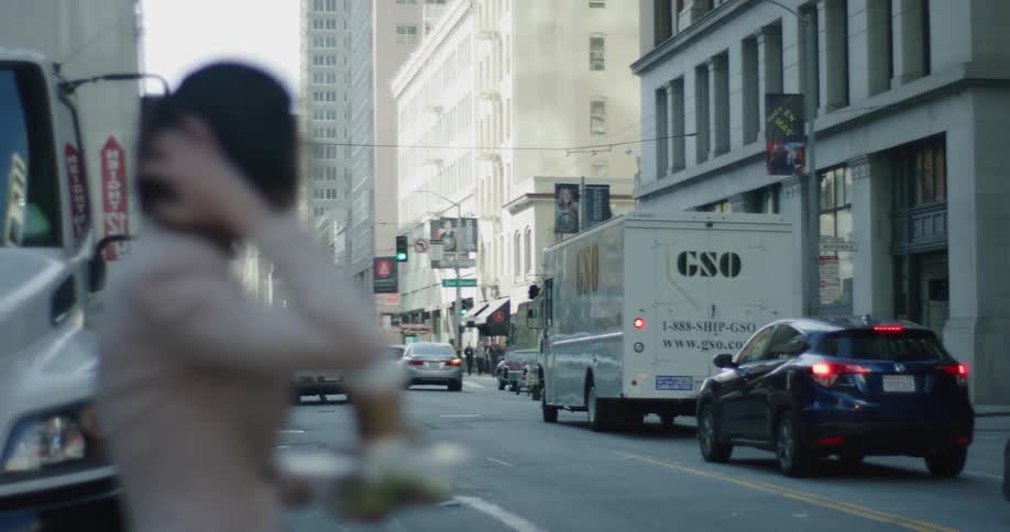 A woman standing at the edge of a street