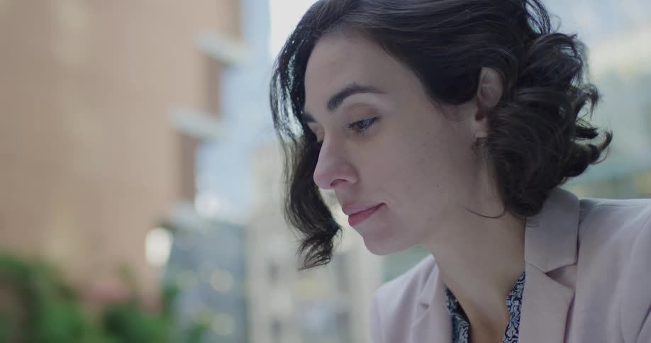 Close up of a young womans face sitting on a street in the city