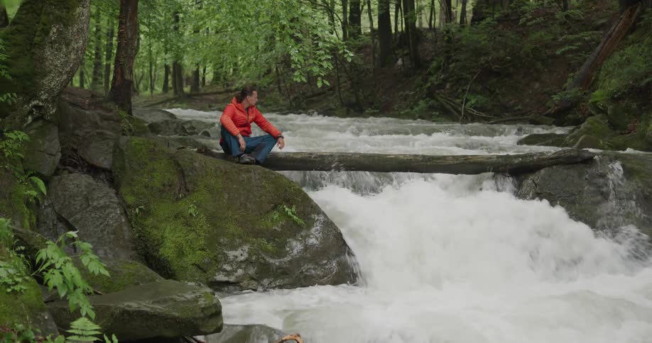 A man standing near a rapids