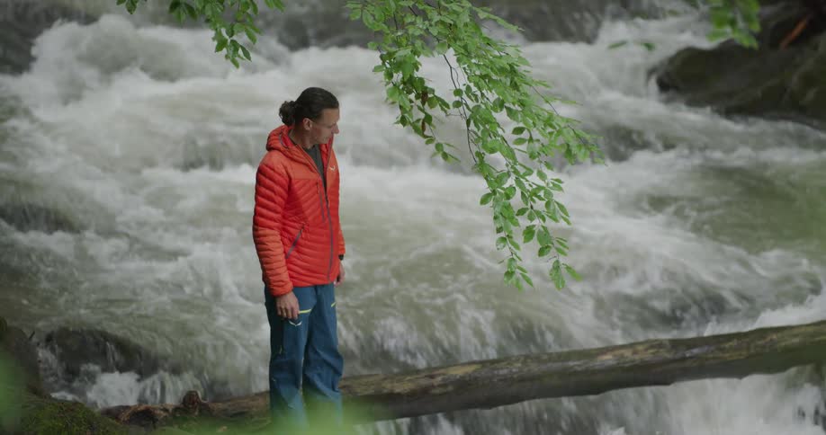 A man standing near a small waterfall