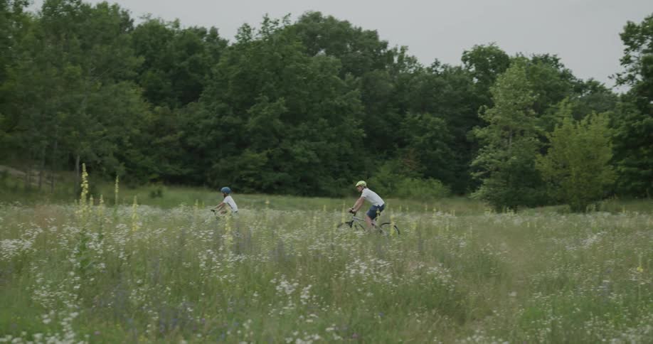 Two children biking in a field