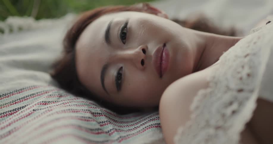 Woman with white blouse lies down on rug in the public park