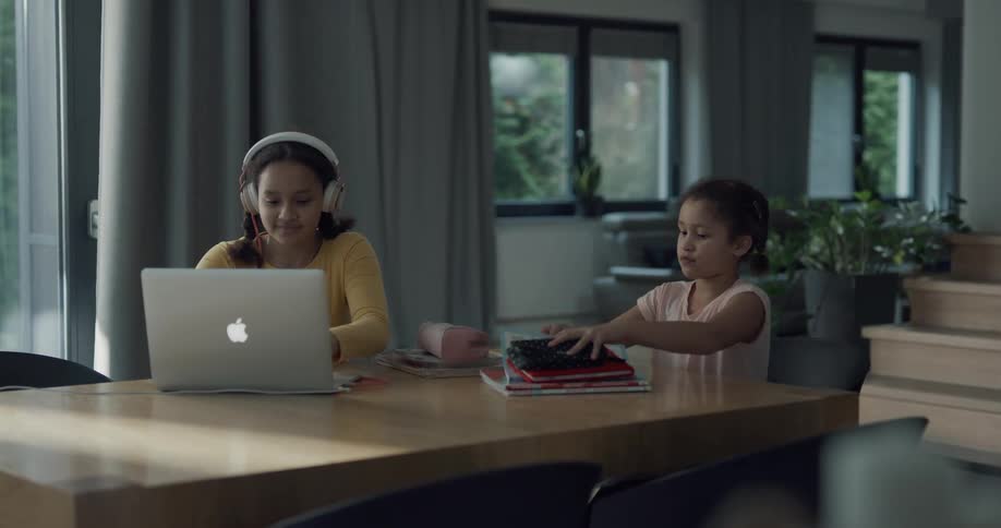 Two girls sit down and open school books