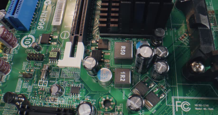 Close up of a green circuit board with metal and plastic components