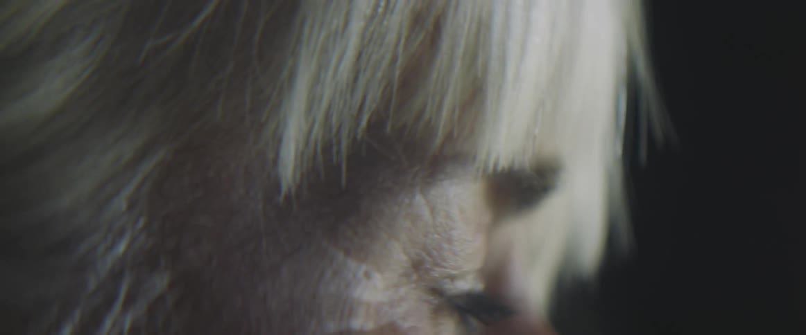 Side view of an elderly womans face with grey hair and wrinkles