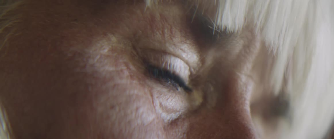 Side view of an elderly womans face with wrinkles shedding tears
