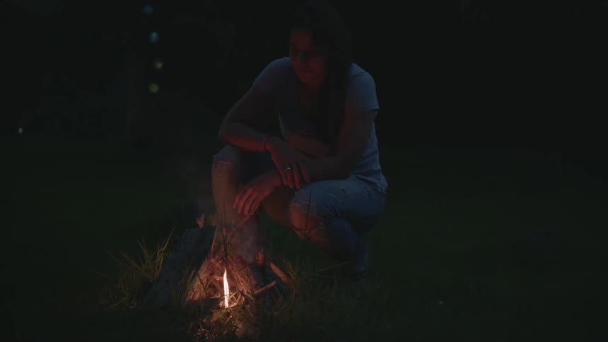 A person sitting in front of a small fire