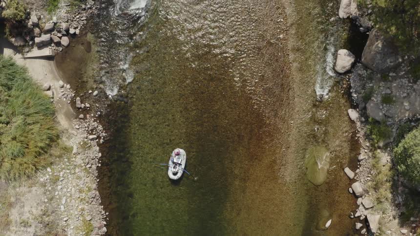 A person is rowing a raft down a river
