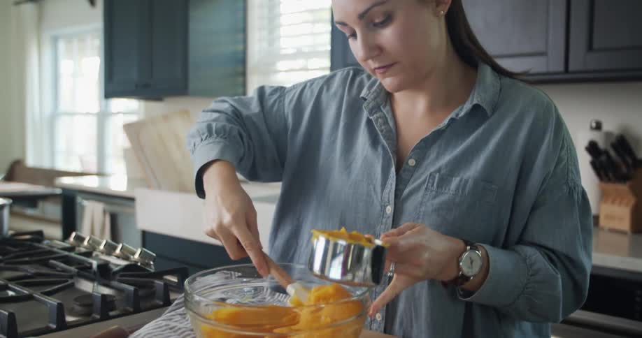A woman is cooking in her kitchen