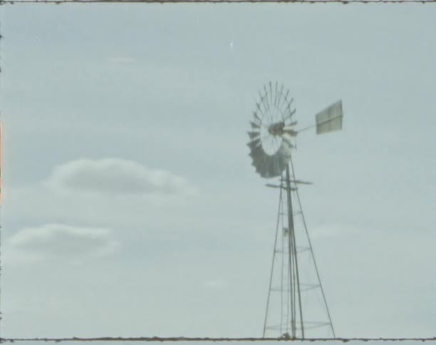 A vintage film of a windmill on a field