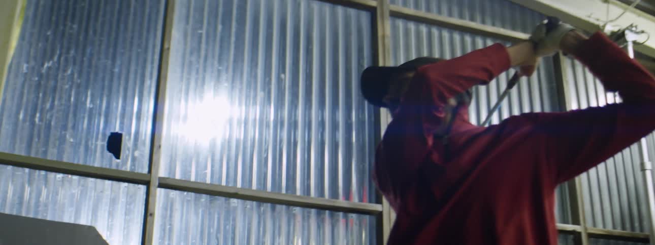 Man inside a building practices his golf swing