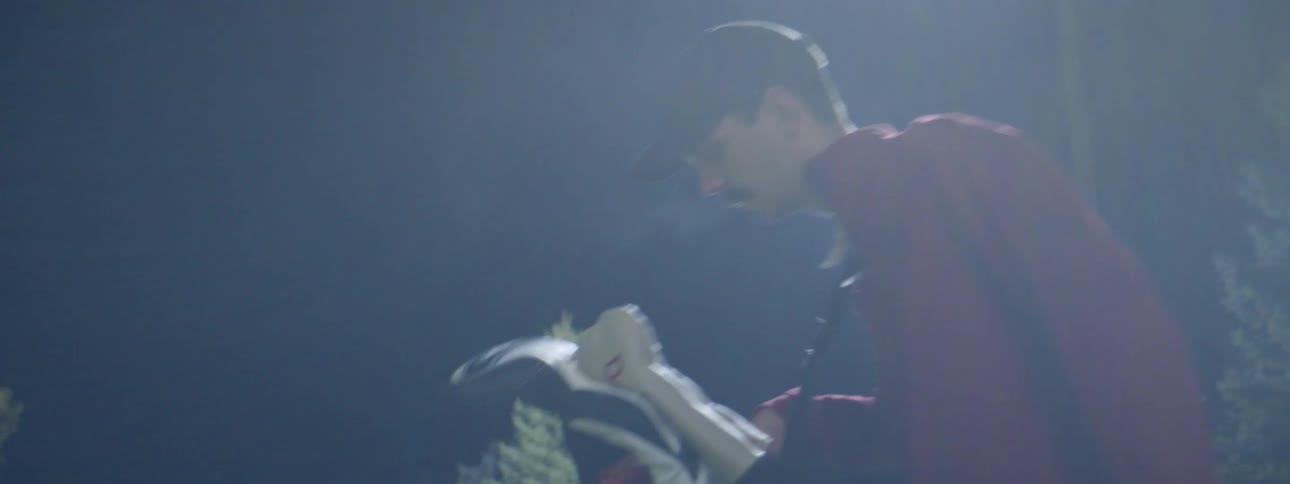 A man walks across a driving range and sets down his golf clubs