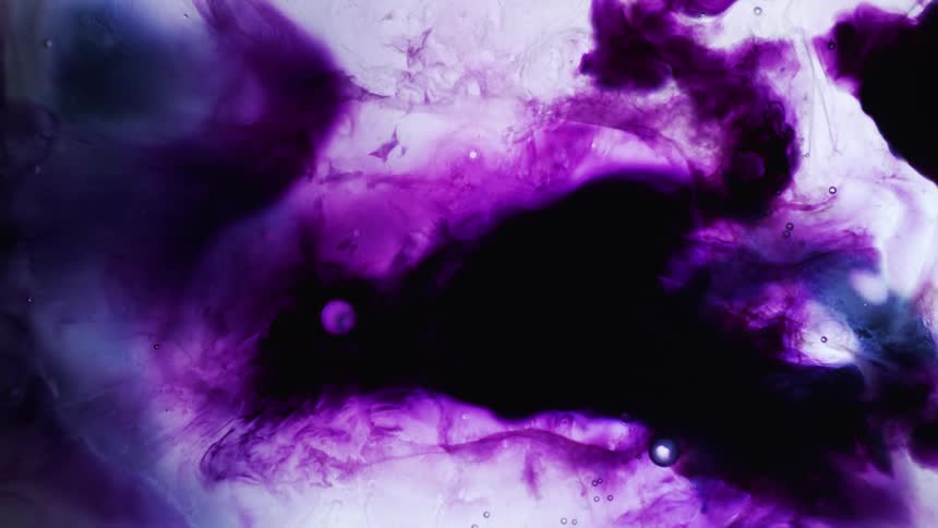 Dark purple dye flows spreads over paler creased mass