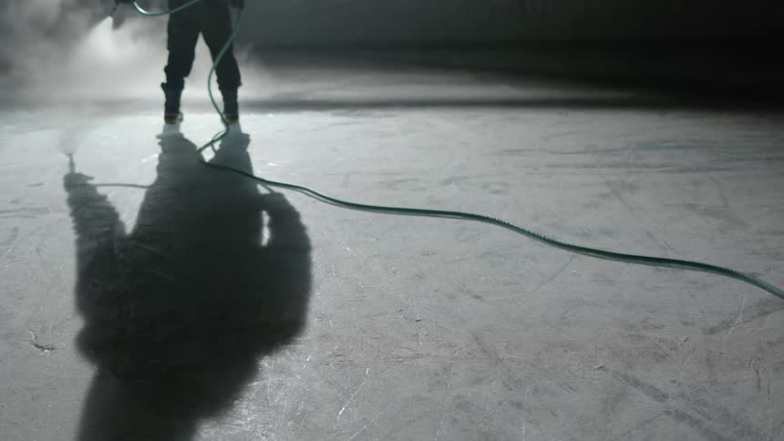 A person hosing down a floor