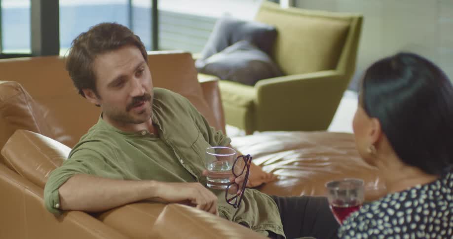 Two people sitting and talking with drinks