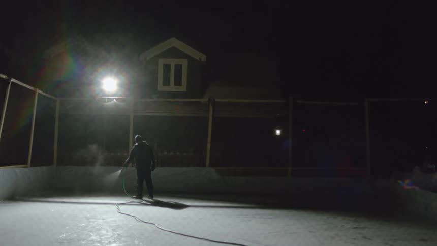 A man spraying concrete by a house