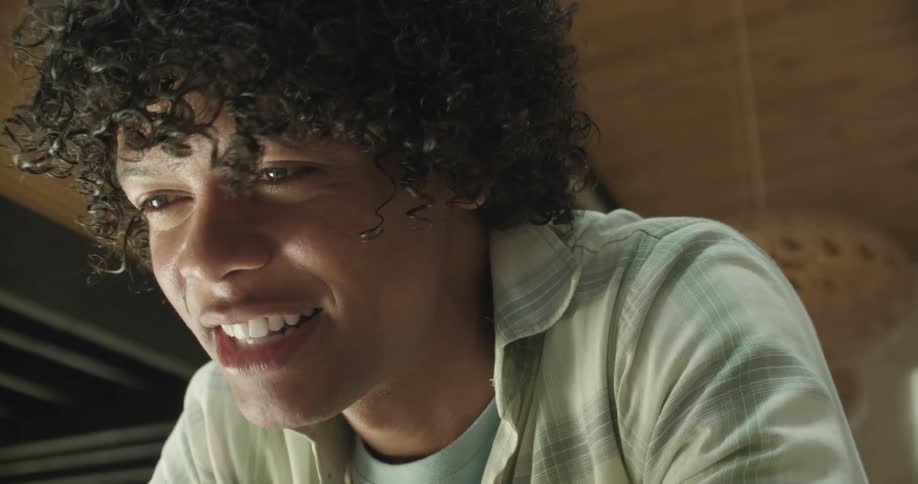 A teenage boy laughs as he talks