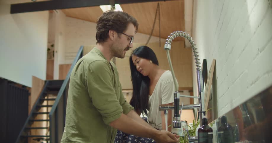 Young couple talking on the kitchen at home