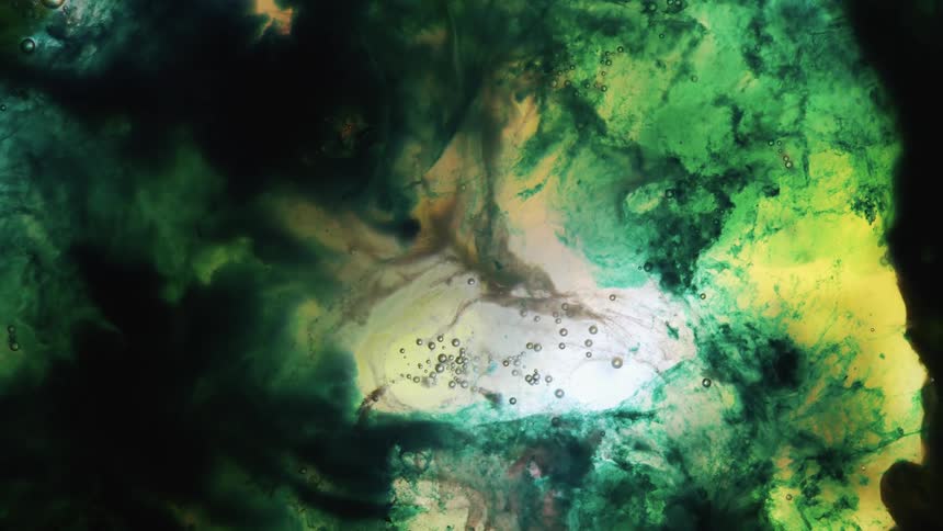 Green yellow black liquid black ink moving and pulsating in abstract patterns