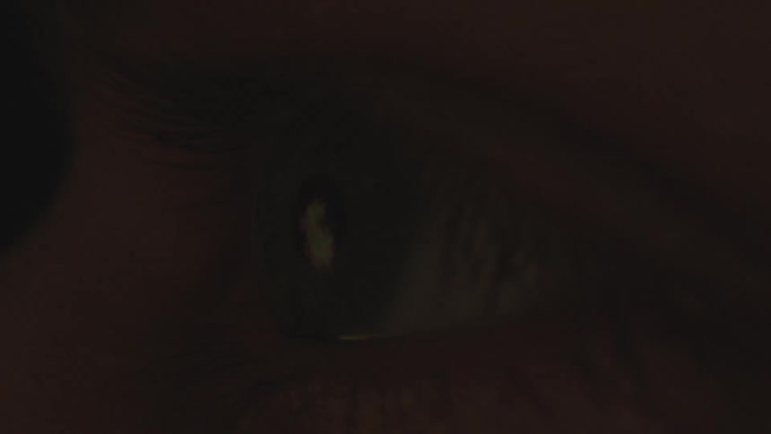 Bright lights flash on a close up of a persons eye