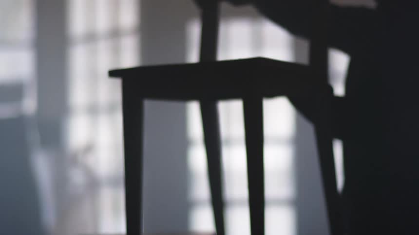 A carpenter sanding a chair