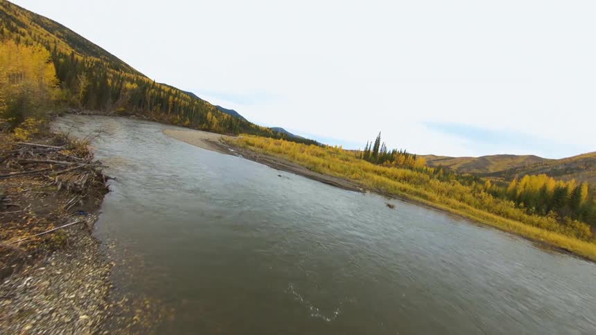 Aerial view of a river crossing the landscape between the mountains at day time