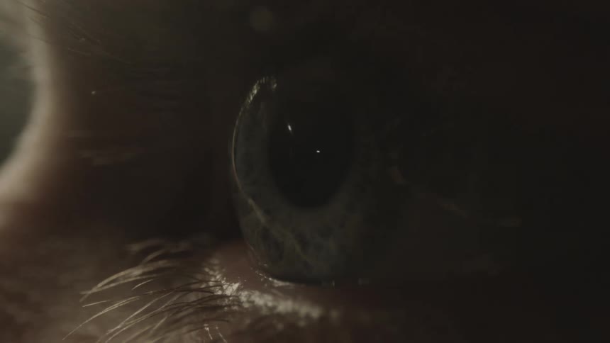 A persons eye with eyelashes blinking