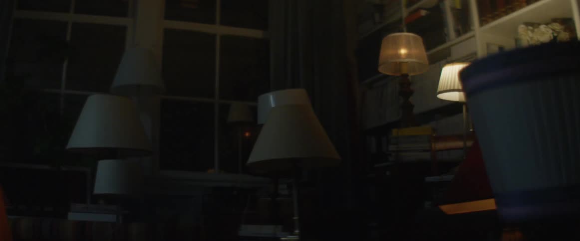 A collection of lamps flash on and off in sequence in the corner of a room in a house at night