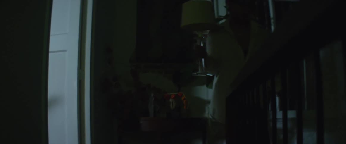 A woman at home unplugs a lamp and picks it up