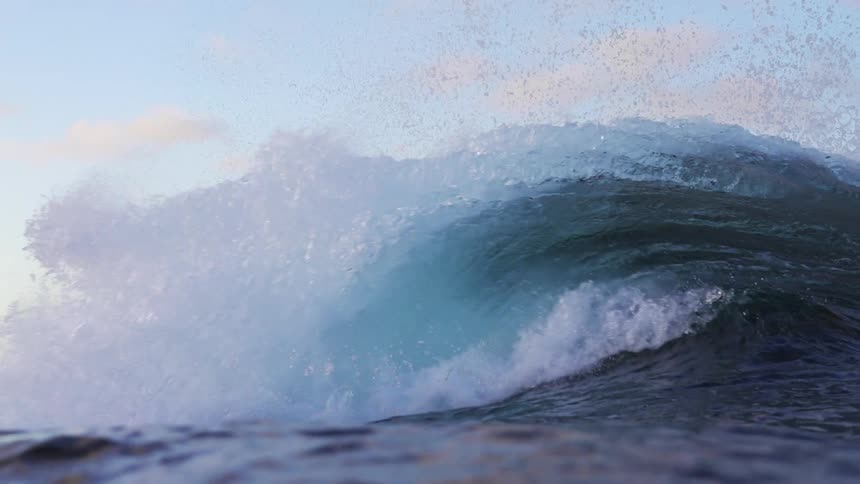 Ocean with a crashing wave against a blue sky