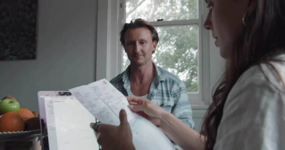 Young couple working from home talk and share documents on the kitchen