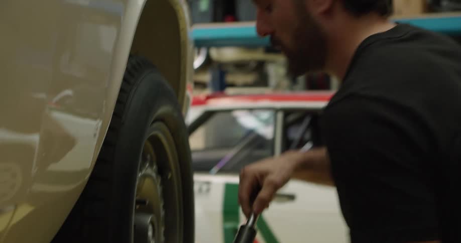 A man taking a tire off a car