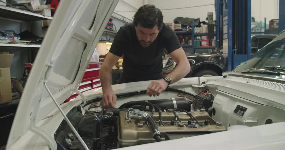 Mechanic checking the engine of a car inside the workshop