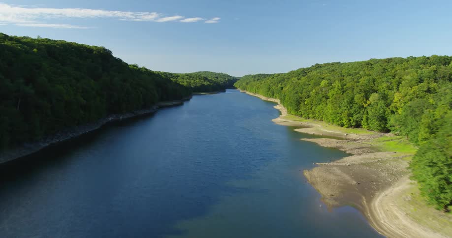 Aerial view of a river and surrounding trees on a sunny day