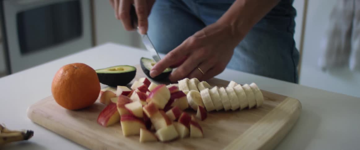 A woman at home cutting fruit