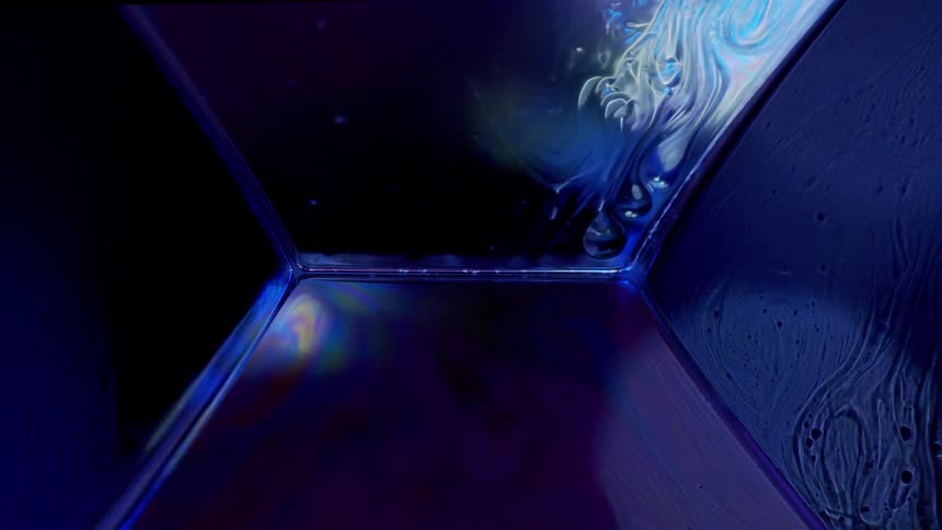 Liquid moves on a surface with compartments and a blue light with a light red hue fading in