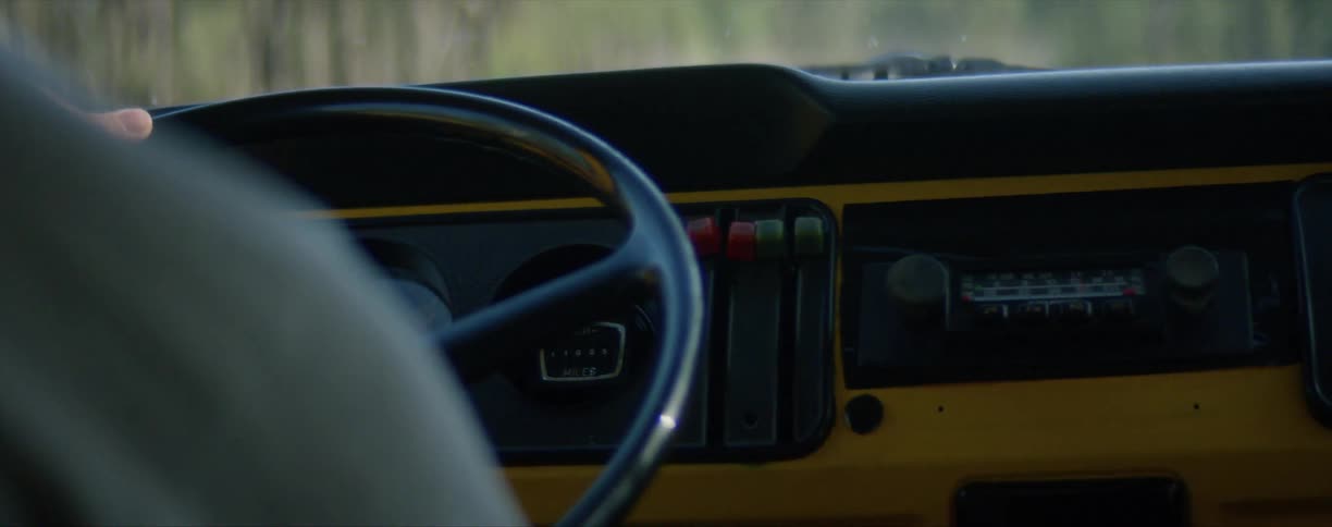 Close up of a mans arms as he drives his vehicle