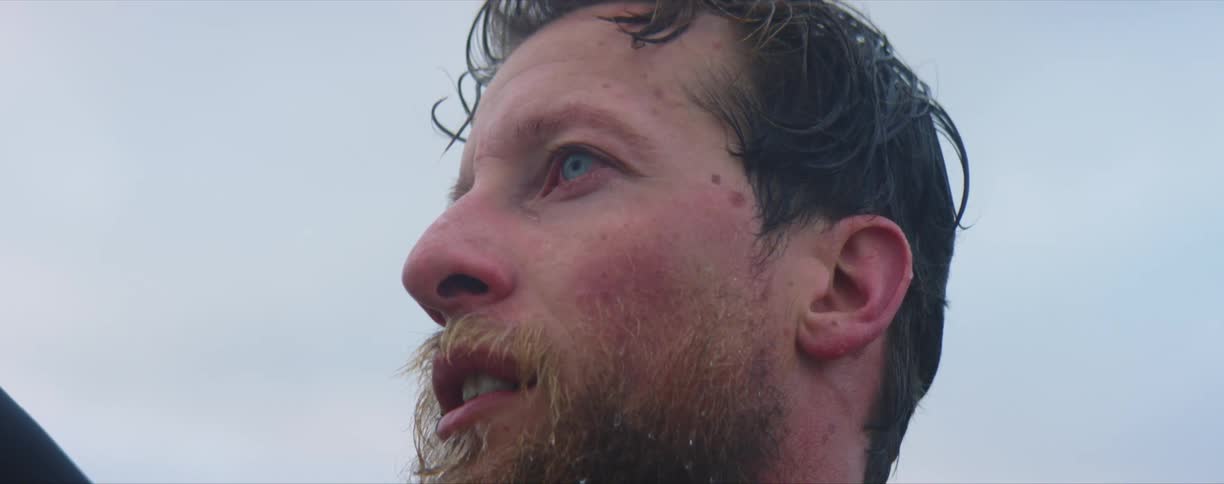 Close up of a bearded mans face looking at the horizon outdoors