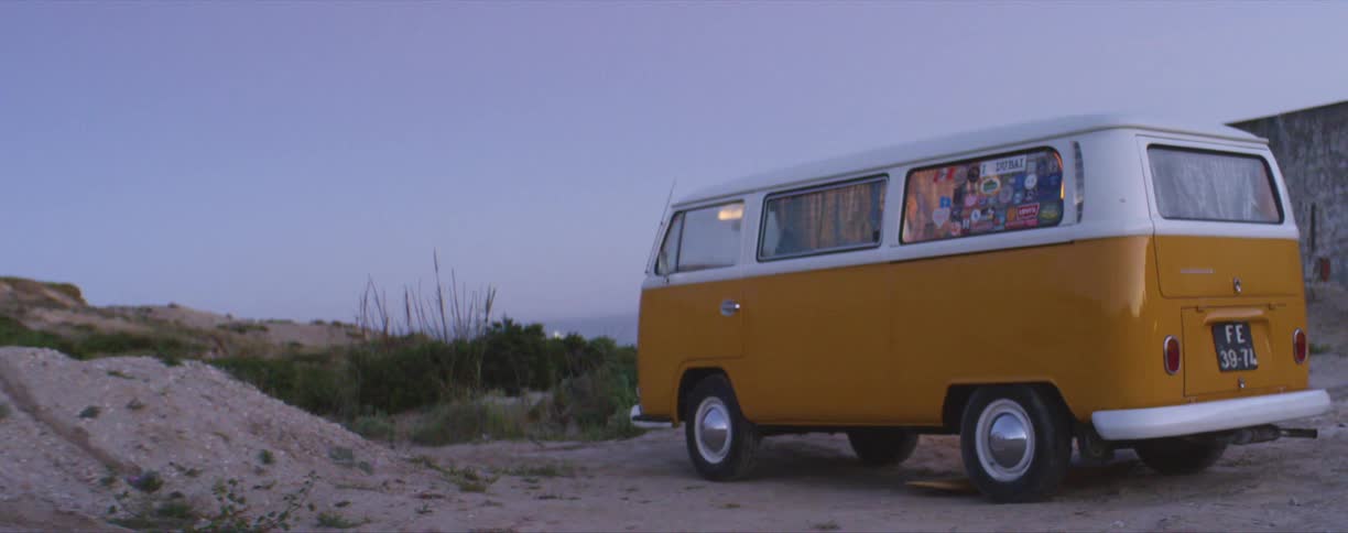 Roof lights turning on inside a bright white and yellow van parked outdoors at evening