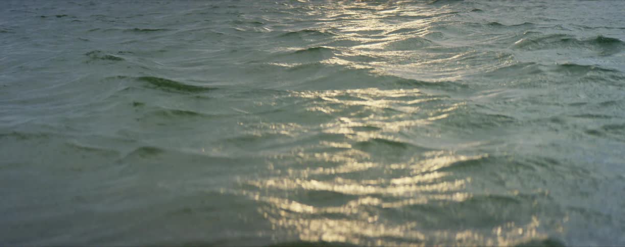 Ocean waves rippling under a sun reflecting onto the water