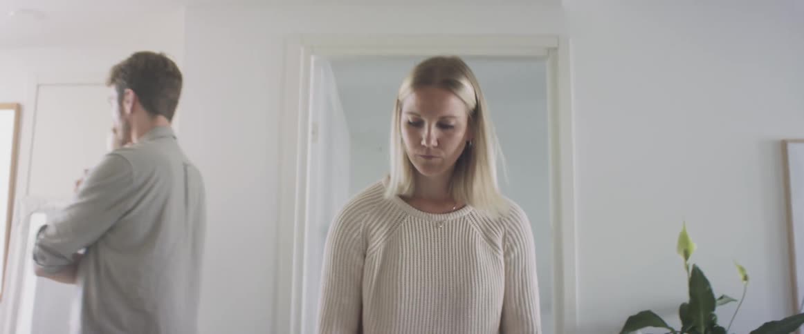 Dramatic zoom on a womans face while she arranges papers on a desk at home